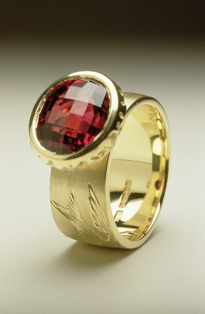 18ct green gold, hand engraved, oval chequerboard cut garnet.