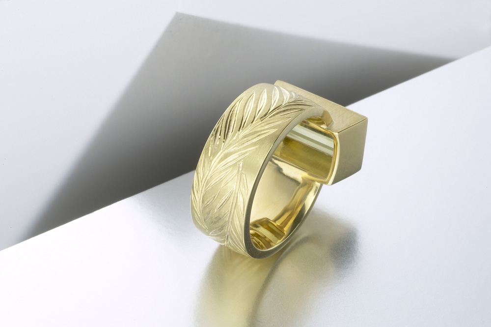 18ct yellow gold, hand engraved cut with interlocking olive branches, olive green tourmaline baguette. Photo: Paul Hartley