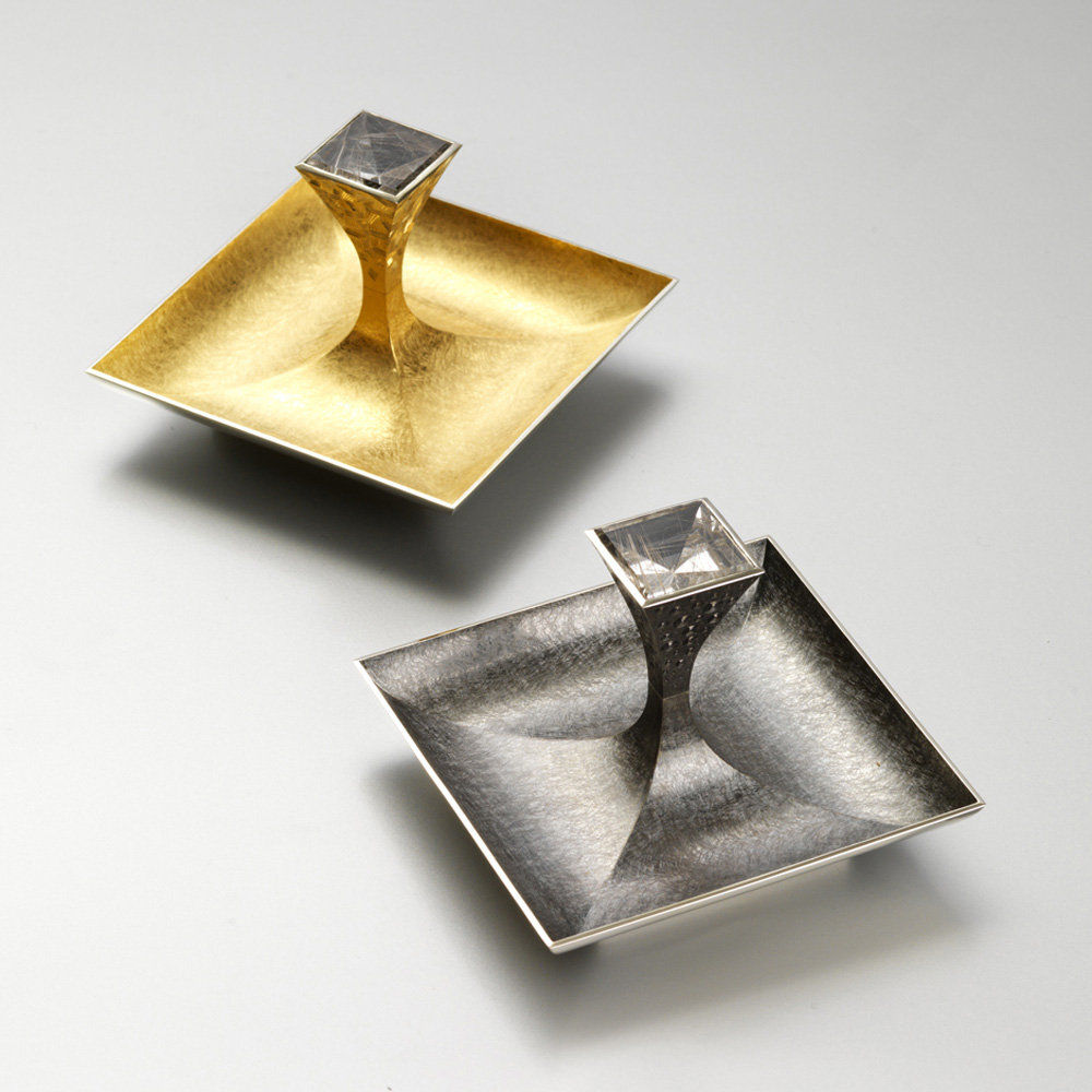 Silver, hand engraved, yellow gilding, black rhodium plate, set with pair of square mirror cut rutilated quartz. Dishes 88mm square. Made for 'Silver with a Pinch of Salt' exhibition at Goldsmiths. 2009. Photo: courtesy The Goldsmiths' Company.