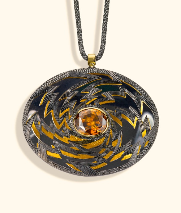 <a href="/node/260">“Golden Lightening” Oval 6cm x 4 cm. Silver hand engraved, hand pierced, mirror behind to reflect the underside.  Stone oval Zircon in orange / brown. set in 18ct gold.  View 1 Face on black reflections, White background</a>