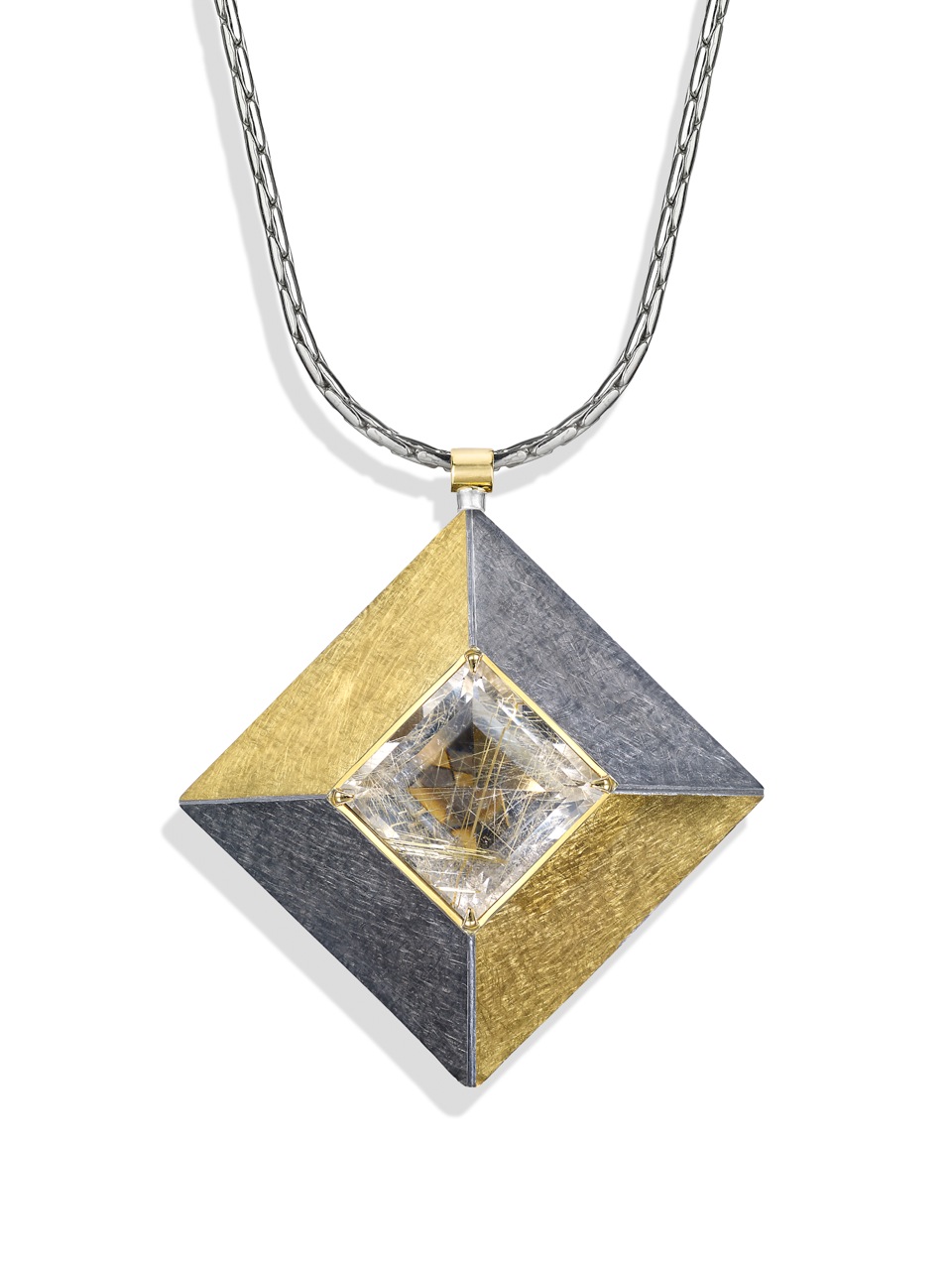 <a href="/node/263">Cardinal Points :  Silver 5.0cm square, scrubbed finish finished in Black Rhodium and gilding,  stone setting 18ct gold, stone Rutilated Quartz . View 5 : face on, Close Up - showing unusual relections in the stone.</a>
