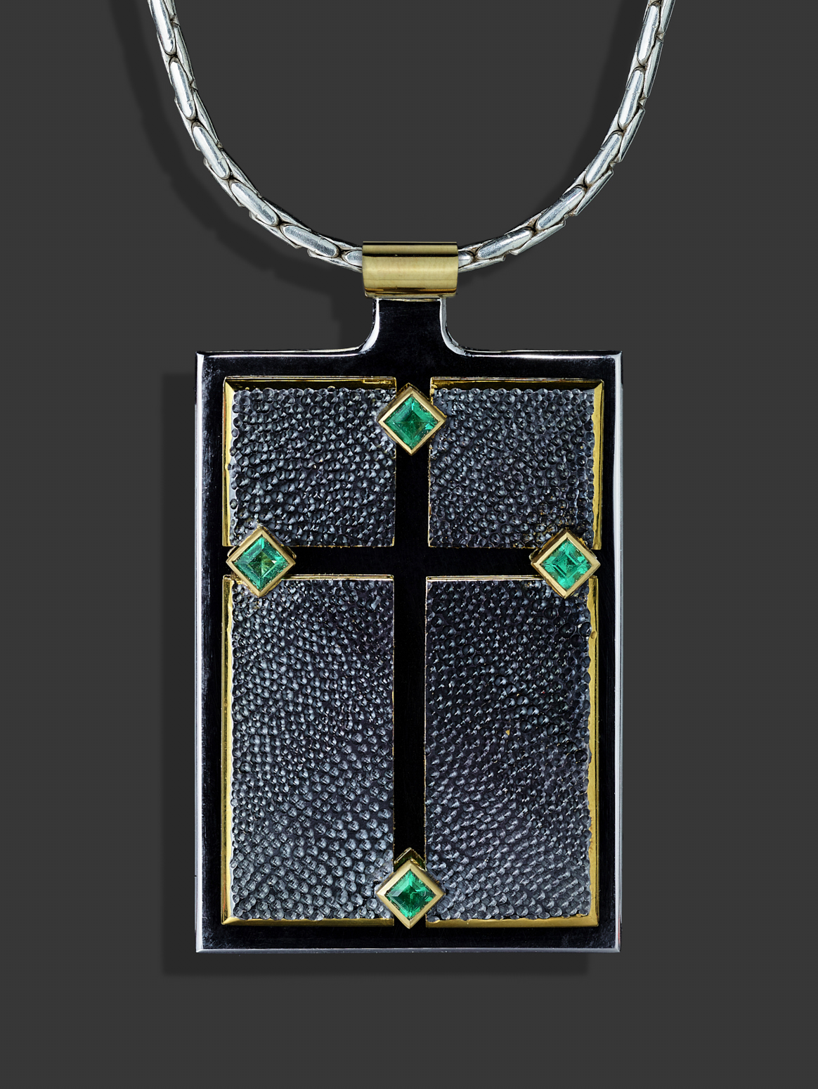 Silver, 18ct gold, four emeralds, gilding and rhodium plate. The cross we see is actually empty space and therefore is 'nothing' as opposed to the 'something' of the four textured top panels.Photo : Simon B Armitt.