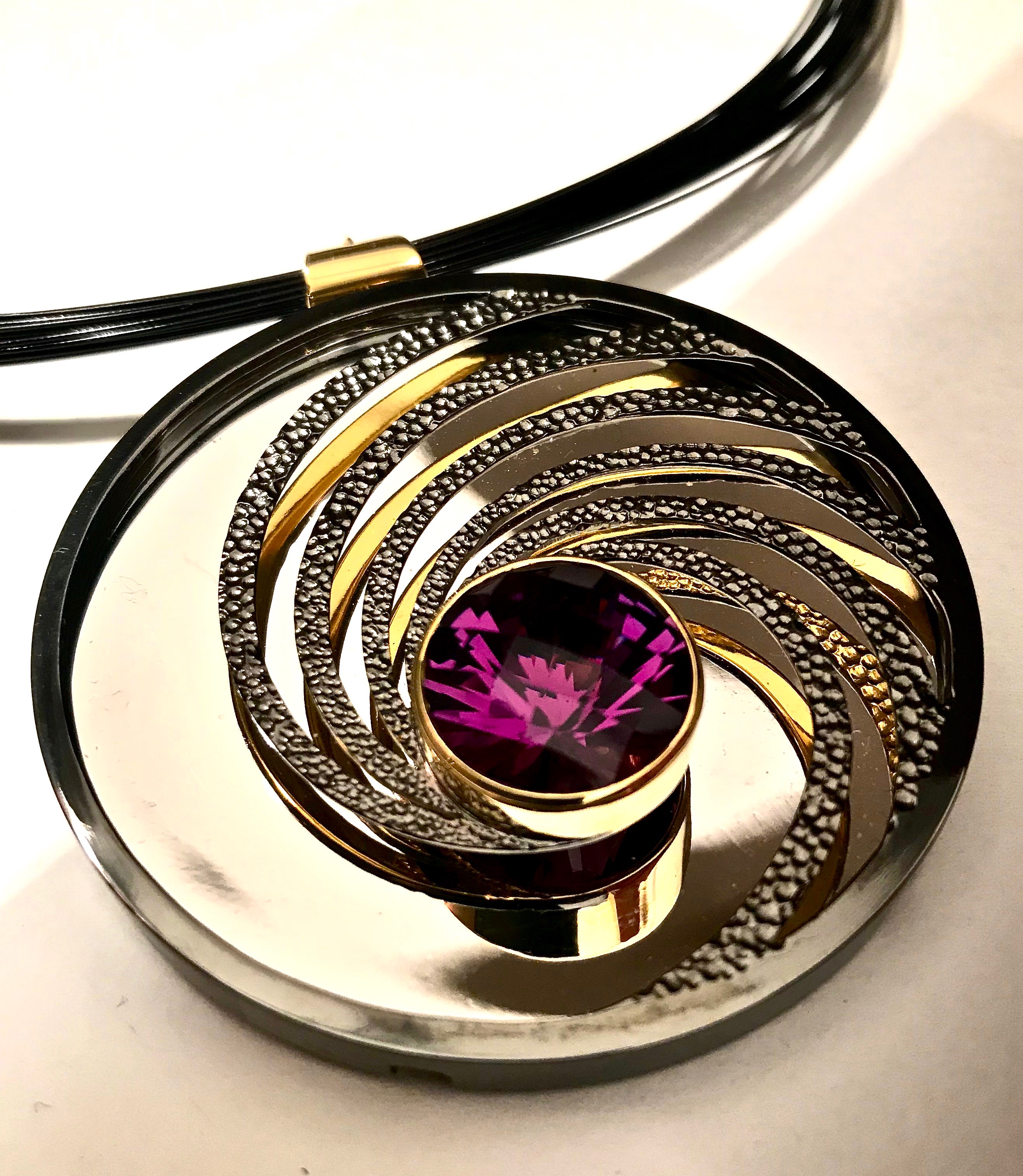 Dark amethyst, silver, part gilded and part rhodium plated. The mirror on the inside back will reflect whatever it is facing - here it’s the sky.