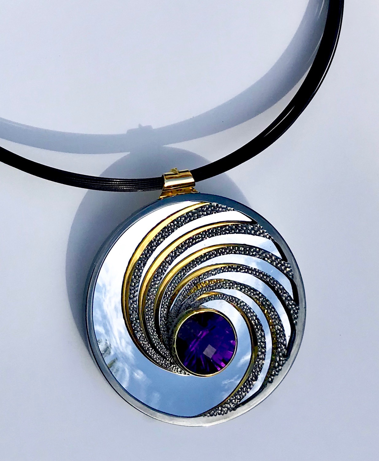 Dark Amethyst, silver, part gilded, part rhodium plated. The mirror on the inside back will reflect whatever its facing - here it’s the sky.