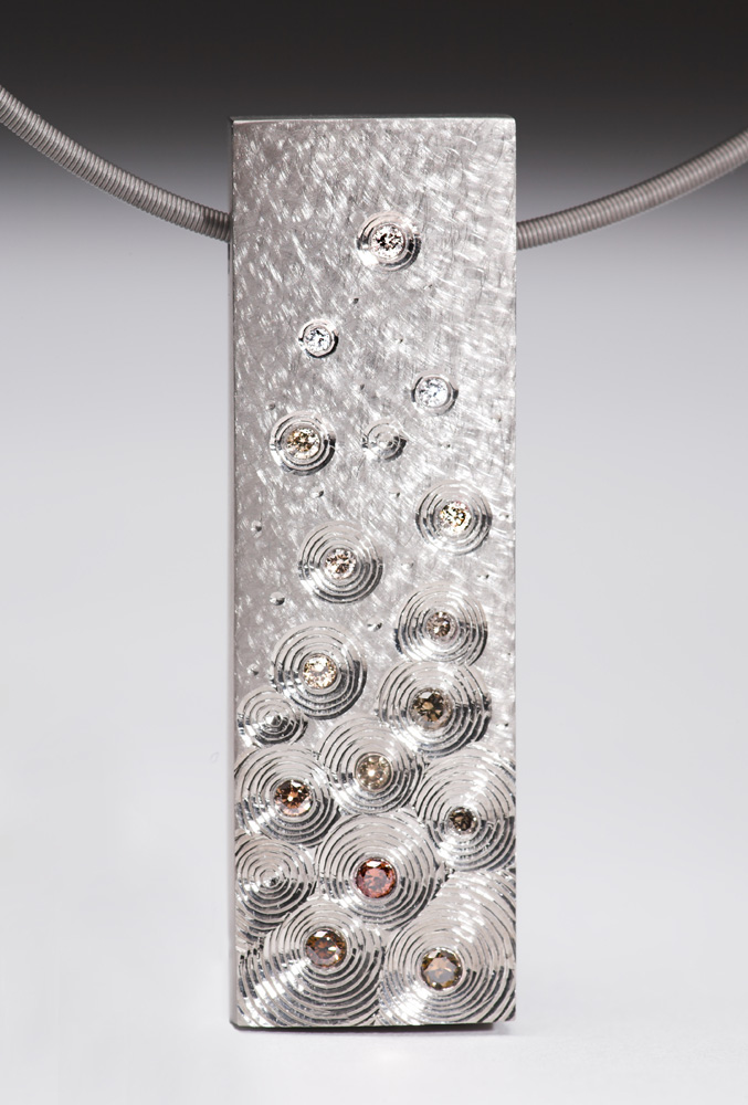 18ct white gold, set with sepia coloured/fading to white diamonds. 5cm x 1.5cm. Titanium chain.