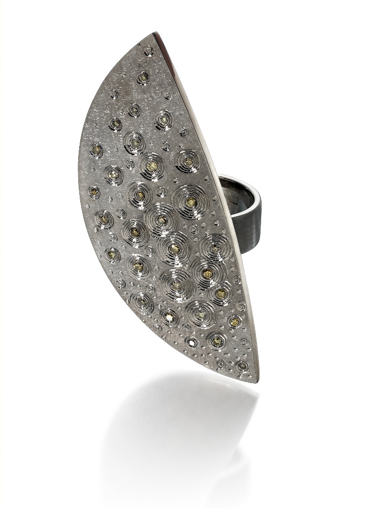 Silver, finished in light and dark grey rhodium, hand engraved, set with yellow/green diamonds.Photo: Simon B Armitt