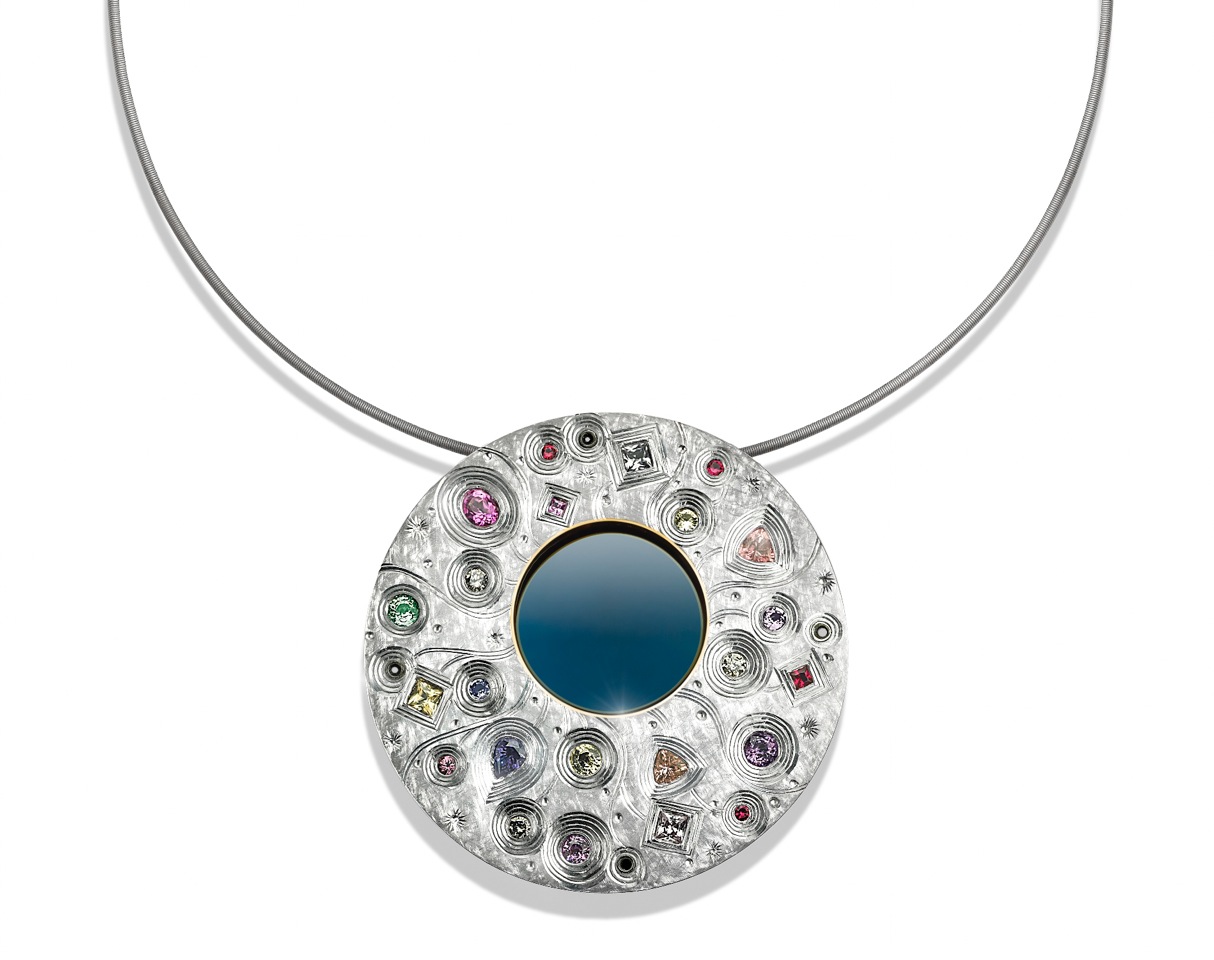Silver finished in white and blue rhodium with some gilding, hand engraved. Set with various coloured sapphires. 6 cm diameter. Titanium chain. 2014.Photo: Simon B Armitt