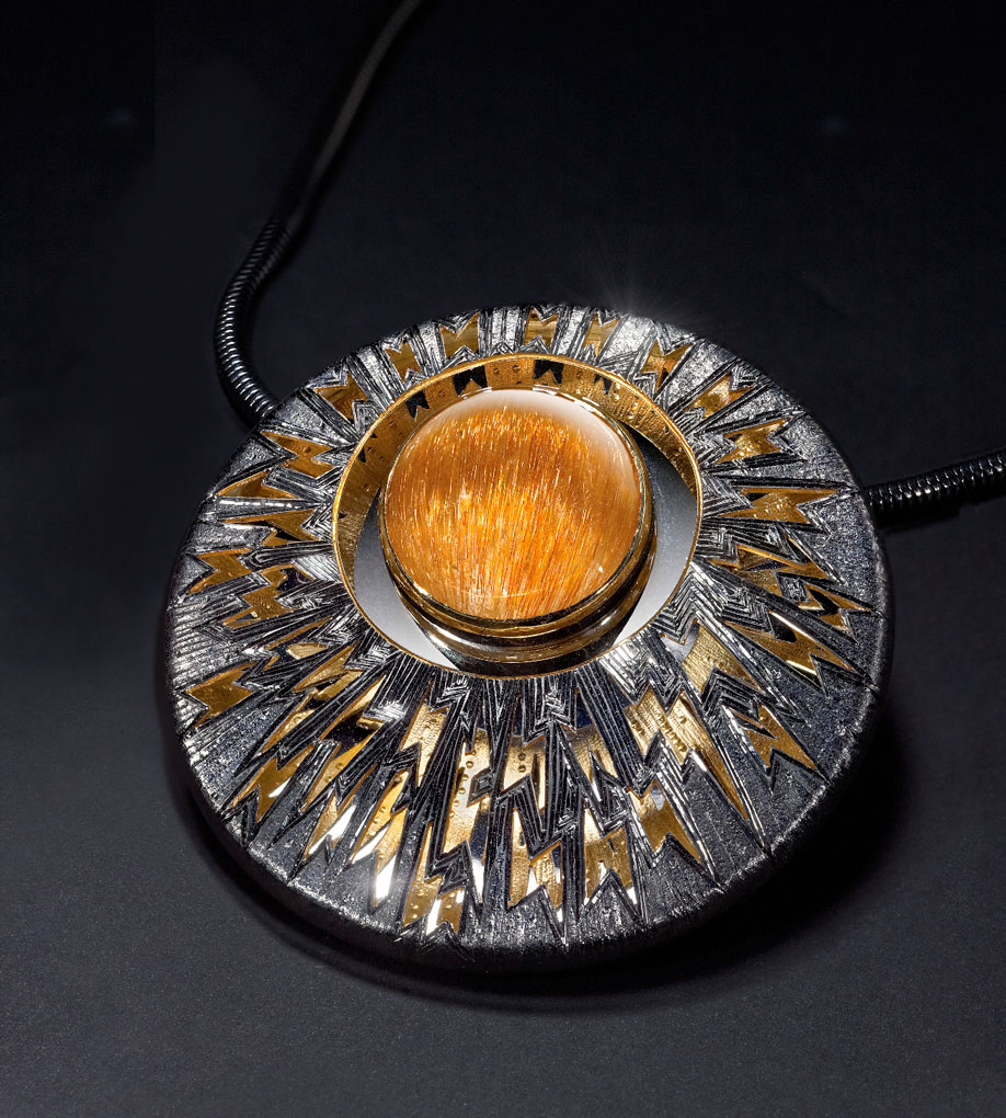 Silver, hand engraved ,set with large cabochon gold-coloured rutilated quartz, silver back mirror-polished to reflect gilded underside of black rhodium plated engraved top.