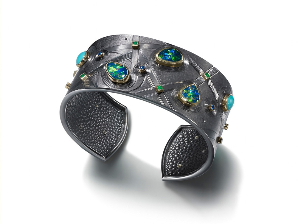 Silver finished in black rhodium, hand engraved, set with opals, turquoise, emeralds and sapphires. Approx. 7 cm wide. 2012.Photo: Simon B Armitt