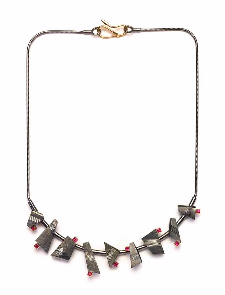 Silver, hand engraved, finished in black rhodium, settings and clasp in 18ct yellow gold, set with 9 square rubies. 2009. Photo: Simon B Armitt