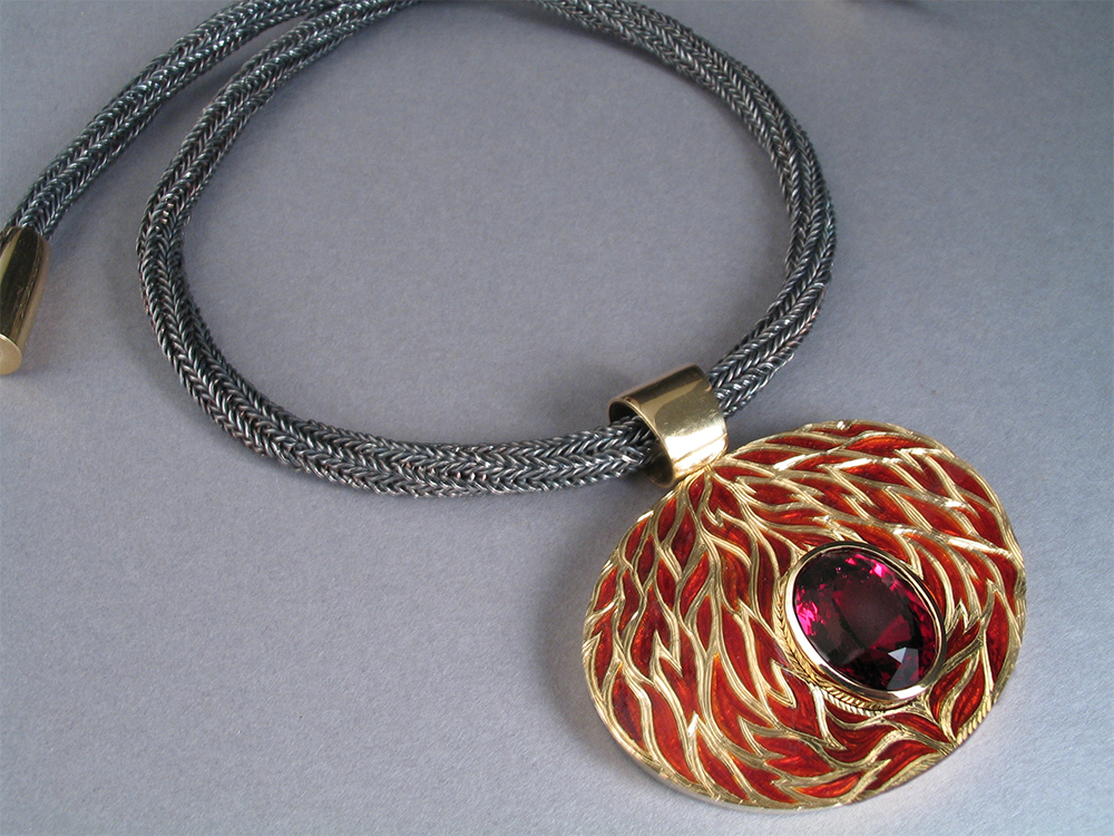 18ct yellow gold drop with champleve red enamel and engraved surface, set with oval red garnet. Silver chain, 18ct yellow gold clasp.Photo: Andra Nelki