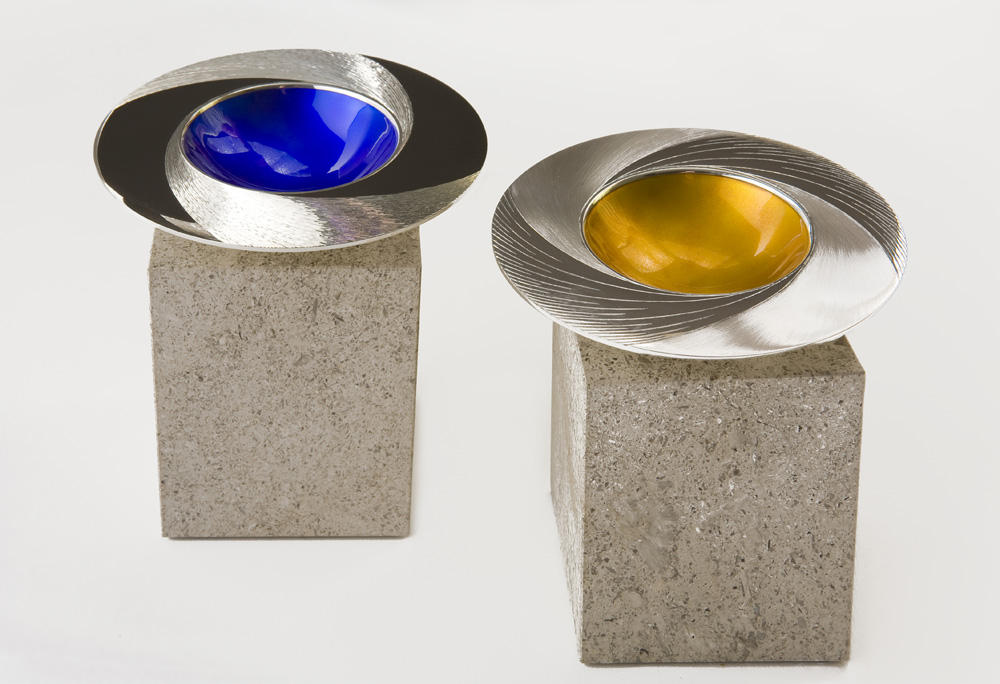 Day and Night Spinning Bowls. 110 mm diameter. Silver,  rim Hand Engraved, centre of bowl enamelled. Limestone base.