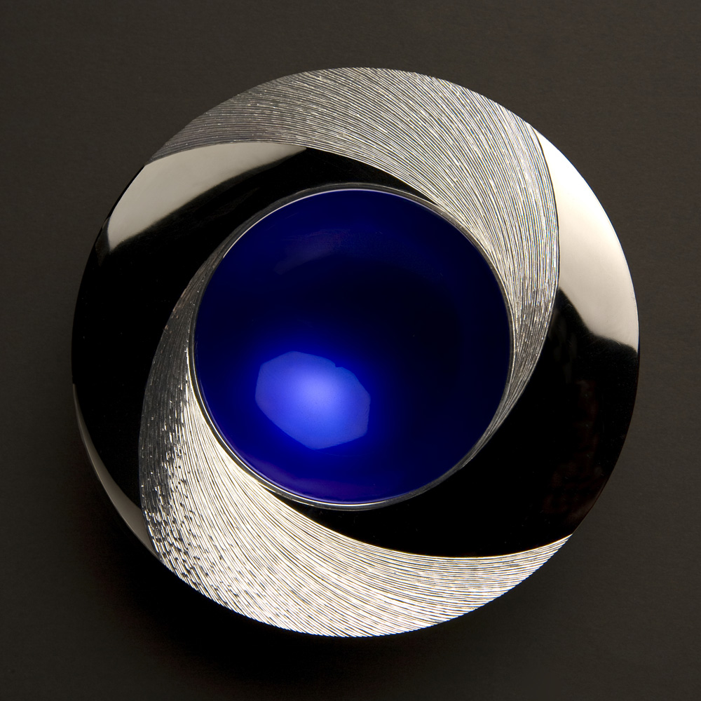"NIGHT" Spinning Bowl 110 mm diameter. Silver,  rim Hand Engraved, centre of bowl enamelled deep blue. Limestone base.