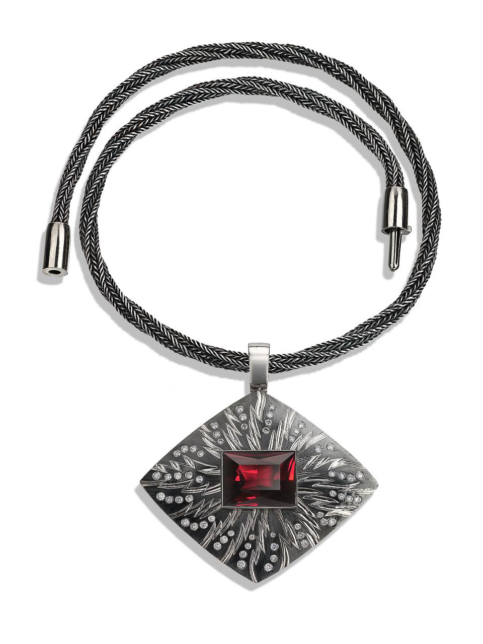 18ct white gold, hand engraved and carved, set with 58 grey diamonds and rectangular garnet 18.77cts, part coloured in black rhodium. Hand knitted 'Sacred Knot' chain in oxidised fine silver  black, white Gold clasp.Photo : Simon B. Armitt