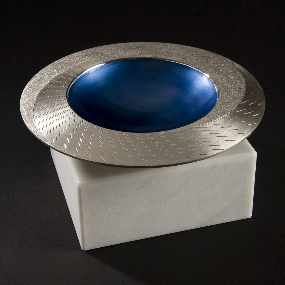 Angle view: RAIN SPINNING BOWL 2008. 150 mm diameter. Brittannia Silver, Moonstone Blue enamel, white marble. Photo: Simon Armitt