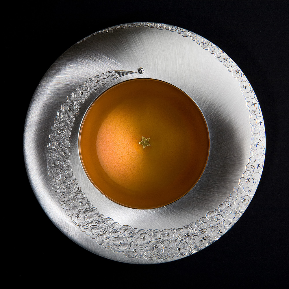 <a href="/jewellery/spinning-comet-bowl-day-2009-silver-hand-engraved-set-grey-diamond-gold-leaf-star-fired">SPINNING COMET BOWL - DAY. 2009, Silver, hand engraved, set with grey diamond, gold leaf star fired into yellow/ orange enamel. 110 mm diam. Photo : Simon B Armitt</a>