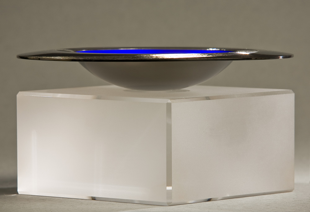 Side view: STARLIGHT BOWL 150 mm diameter. Britannia Silver. Blue Enamel, Hand Engraved. Brushed and striated finish. Base polished Limestone. Bowl is designed to spin gently on its stone base. Photo : Simon Armitt
