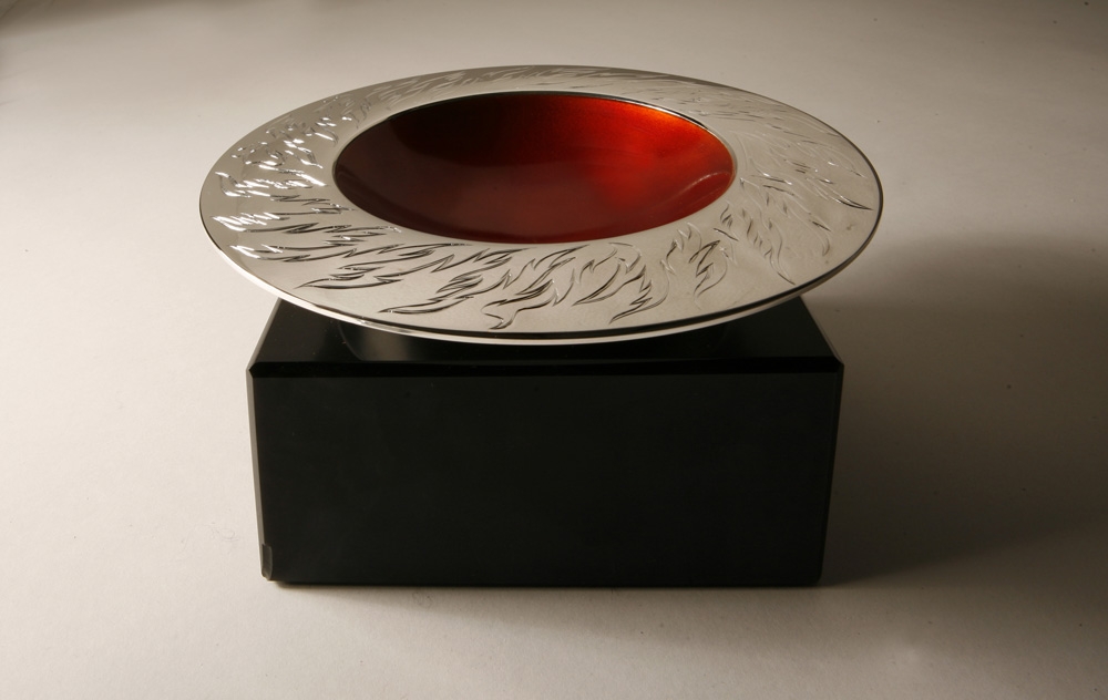 <a href="/jewellery/ange-view-elements-spinning-bowl-fire-150mm-diam-brittania-silver-hand-engraved-orange">Ange view: ELEMENTS SPINNING BOWL - FIRE 150mm diam. Brittania Silver, Hand Engraved, Orange enamel. Photo Andra Nelki</a>